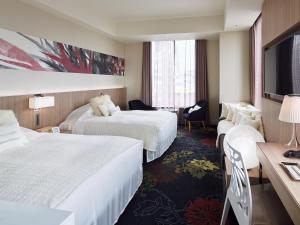 a hotel room with two beds and a desk at Millennium Mitsui Garden Hotel Tokyo - Ginza in Tokyo