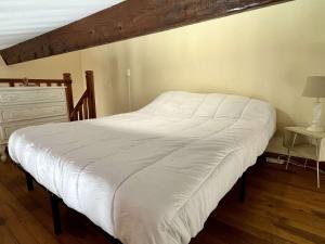 a white bed in a bedroom with a wooden floor at Appart 2 Pièces mezzanine 4 couchages ARGELES SUR MER AR090-010 in Argelès-sur-Mer