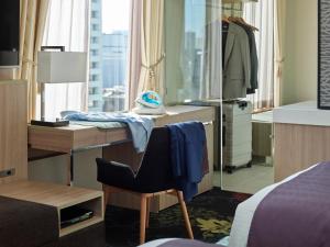 a bedroom with a desk and a bed and a mirror at Millennium Mitsui Garden Hotel Tokyo - Ginza in Tokyo