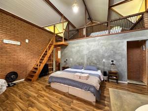 a bedroom with a large bed and a staircase at Chalé Jacarandá - Hidro - Wifi e mais in Sapucaí-Mirim +16 photos