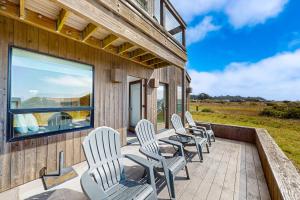 a row of chairs sitting on the deck of a house at Blue Mermaid in Sea Ranch