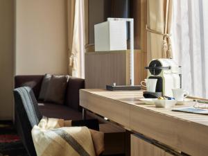 a kitchen with a counter with a chair and a table at Millennium Mitsui Garden Hotel Tokyo - Ginza in Tokyo