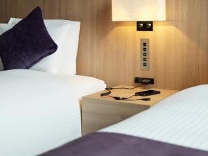 a hotel room with two beds and a phone on a night stand at Millennium Mitsui Garden Hotel Tokyo - Ginza in Tokyo