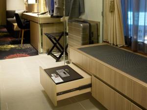 a room with a bed with a drawer and a desk at Millennium Mitsui Garden Hotel Tokyo - Ginza in Tokyo