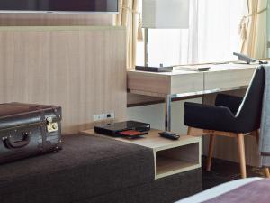 a room with a desk and a chair with a suitcase at Millennium Mitsui Garden Hotel Tokyo - Ginza in Tokyo
