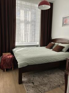 a bedroom with a bed and a large window at Przytulny apartament in Chorzów