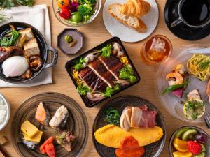 a wooden table with plates of food on it at Millennium Mitsui Garden Hotel Tokyo - Ginza in Tokyo