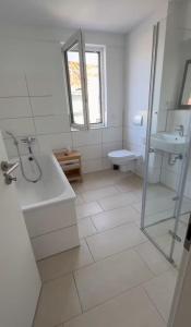 a white bathroom with a tub and a sink at Messe Düsseldorf und Essen Flughafen in Ratingen