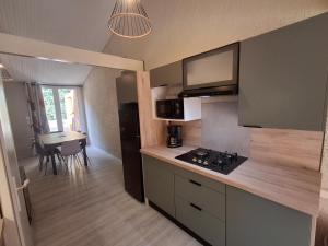 une petite cuisine avec une cuisinière et une table dans l'établissement Cottage familial 3 chambres 2 terrasses forêt, à Mareuil-sur-Lay