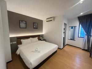 a bedroom with a white bed and a window at Havona Comfort Bandar Putra Kulai - Express Check-In in Kulai