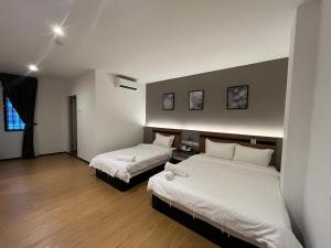 a room with two beds in a room with at Havona Comfort Bandar Putra Kulai - Express Check-In in Kulai