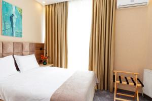 ein Schlafzimmer mit einem weißen Bett und einem Fenster in der Unterkunft Aniko Hotel in Batumi