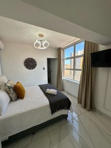ダーバンにあるOceanic Luxury Apartment 76のベッドと大きな窓のある寝室 +26枚の写真