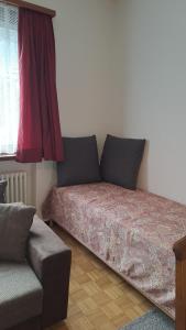 a bedroom with a bed and a couch and a window at Casa Di Vacanza Cevio in Cevio