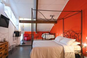 une chambre avec un lit avec un mur orange dans l'établissement Palazzo della Loggia B&B, à Naples