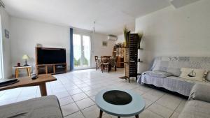 un salon avec un canapé et une télévision dans l'établissement Villa LA DIVA Agréable villa familiale climatisée proche plage - 3 chambres - jardin et terrasse, à Saint Cyprien Plage