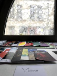 a pile of books sitting on a table in front of a window at Arènes 1 à deux pas du centre historique in Besançon