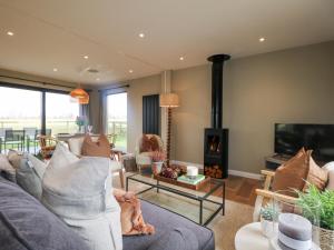 un salon avec un canapé et une cheminée dans l'établissement Holm Oaks Cottage, à Godalming