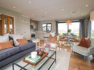 un salon avec un canapé et une table dans l'établissement Holm Oaks Cottage, à Godalming