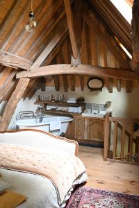 a kitchen with wooden cabinets and a bed in a room at Gîte Les Grenouilles in Le Mesnil-Simon