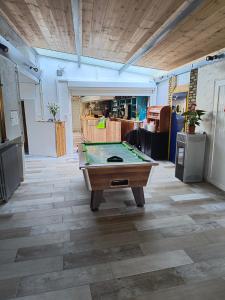 a pool table in the middle of a room at La Marie Galante Appart'Hotel in Saint-Georges-dʼOléron