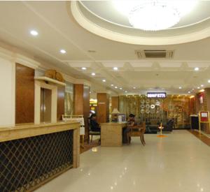 a lobby with a person sitting in a chair at The New Marrion in Bhubaneshwar