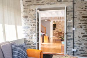 een open deur naar een woonkamer met een stenen muur bij Granary Cottage with hot tub on organic farmland in Lampeter