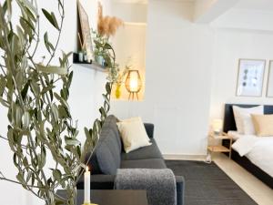 Cheap, Near Beach & Easy Parking - by Solstad في كافالا: غرفة معيشة بها أريكة وزرع