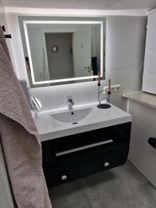 a bathroom with a sink and a mirror at Ferienwohnung - Nachtigall 1 in Bad Hersfeld +31 photos