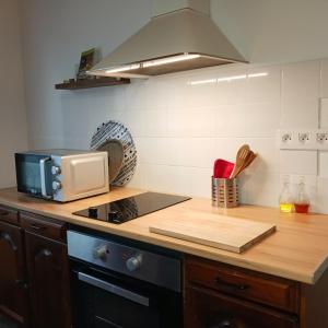 a kitchen with a microwave and a stove top oven at Gîte les Bois - 45 m2 in Orcival