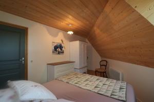 a bedroom with a bed and a wooden ceiling at La Fermette de Loucheyre in Saint-Amandin