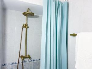 Cheap, Near Beach & Easy Parking - by Solstad في كافالا: دش مع ستارة دش زرقاء في الحمام +20 صورة