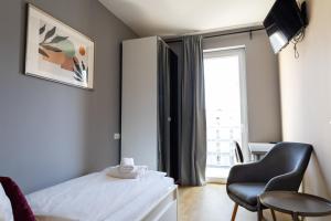 a bedroom with a bed and a chair and a window at Di Verdi Imperial Hotel in Budapest