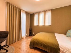 una camera da letto con un letto, una finestra e una sedia di Home Stroy in Tokyo - Luxury Villa Minowa&Ueno-三ノ輪一戸建て&東京屋語 a Tokyo