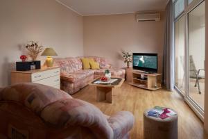 a living room with a couch and a tv at Palmaja in Kaštela