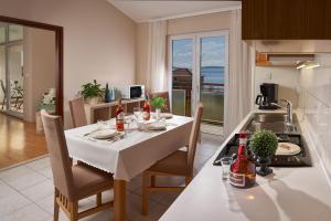 a kitchen with a table with a white table cloth at Palmaja in Kaštela