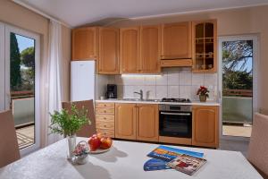 a kitchen with wooden cabinets and a table with fruit on it at Palmaja in Kaštela