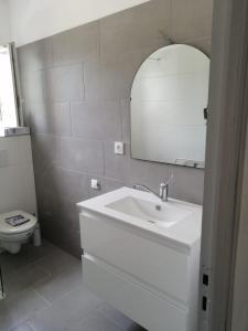 a white bathroom with a sink and a toilet at Appartement confort in Île de Diane +21 photos