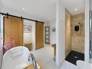 a bathroom with a tub and a shower and a sink at The Cottage at Woodlands in Lynton +21 photos
