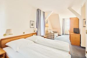 a hotel room with two beds and a television at Hotel & Restaurant zum Ritter in Attendorn