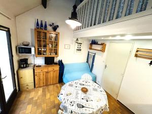 a living room with a blue couch and a table at Maisonnette 2 pièces Mezzanine 4 pers avec piscine extérieure chauffée ADELA in Guidel