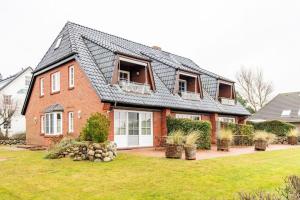 une maison en briques rouges avec un toit noir dans l'établissement Luxus Heefwai, à Morsum