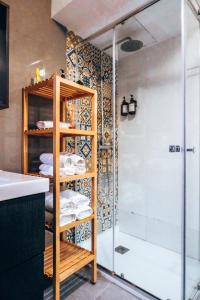 a bathroom with a shower and a shelf with towels at Casa San Roque in Seville
