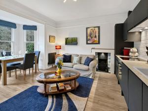 Una cocina y una sala de estar con un sofá y una mesa. en The Penthouse at Woodlands, en Lynton
