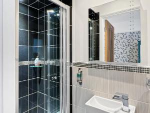 un baño con lavabo y espejo en The Penthouse at Woodlands, en Lynton 16 fotos más