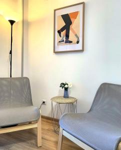 a waiting room with two chairs and a vase of flowers at Peppers Studio in Bucharest