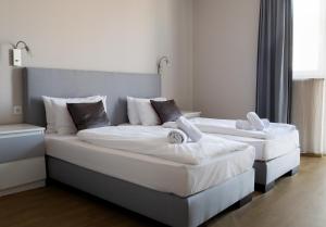 two beds with white sheets and pillows in a room at Di Verdi Imperial Hotel in Budapest