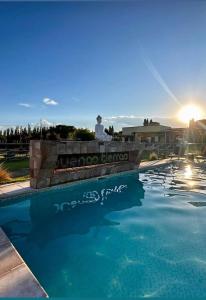 Ein Mann, der an einer Wand neben einem Pool sitzt. in der Unterkunft Buenas Tierras Cabañas in San Rafael