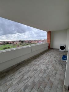an empty room with a large window in a building at Petrocelli apartment in La Romanina
