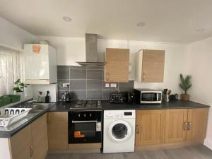 a kitchen with a washing machine and a microwave at Cosy 2 Room Space Near Station in Mitcham +11 photos